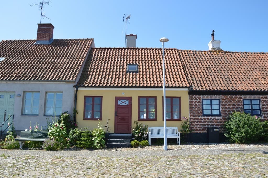 Kulörta hus längs kullerstensgata i Simrishamn, Skåne