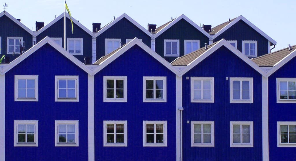 Blå trähus med vita fönster — privat bostadsmarknad